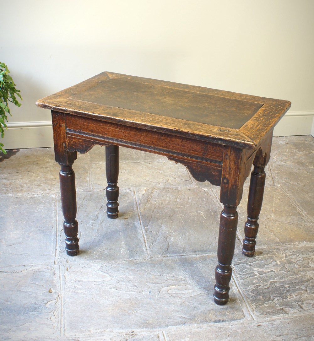 An early 17th century dark oak table with a framed rectangular top, turned legs, and pegged mortise and tenon joinery. View III