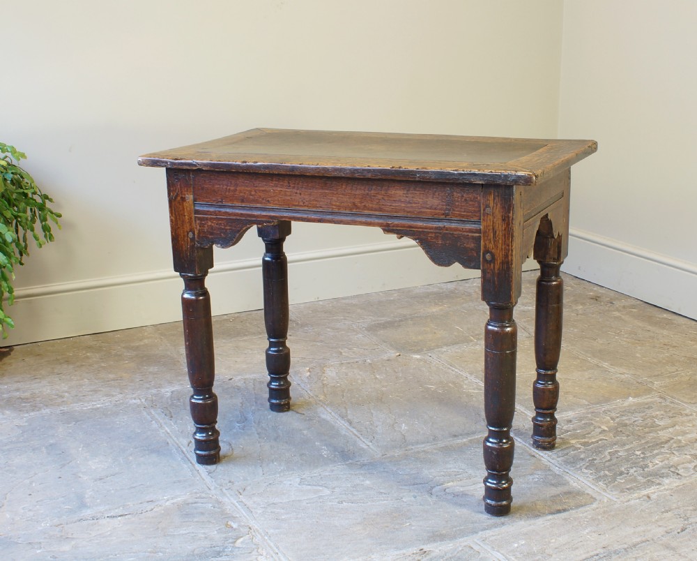 An early 17th century dark oak table with a framed rectangular top, turned legs, and pegged mortise and tenon joinery. View VII
