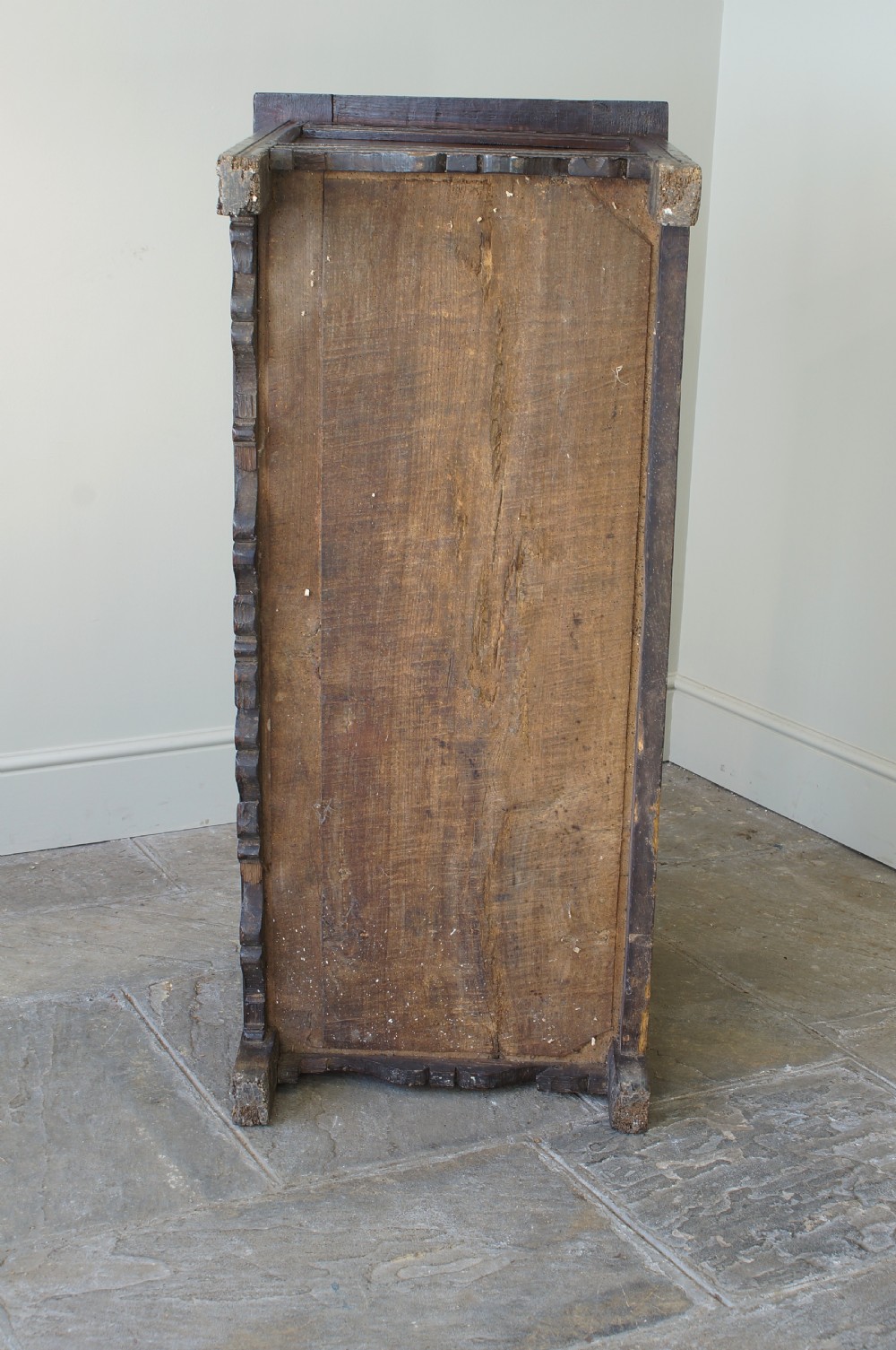 A 17th-century dark oak coffer featuring carved floral panel decoration, a lunette frieze, and a twin-panelled hinged lid. View XVIII
