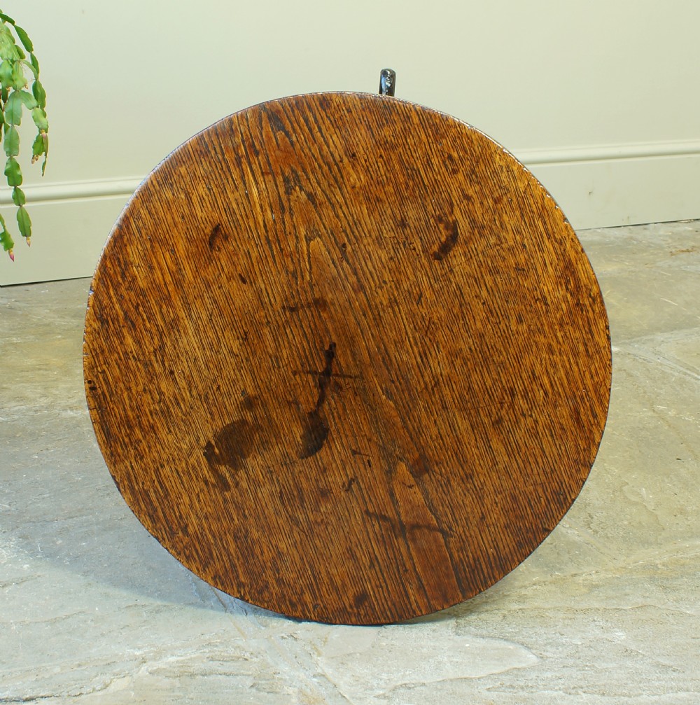 A small circular 18th-century oak tripod table with a turned central column and three curving legs, viewed from above against a neutral background. View II