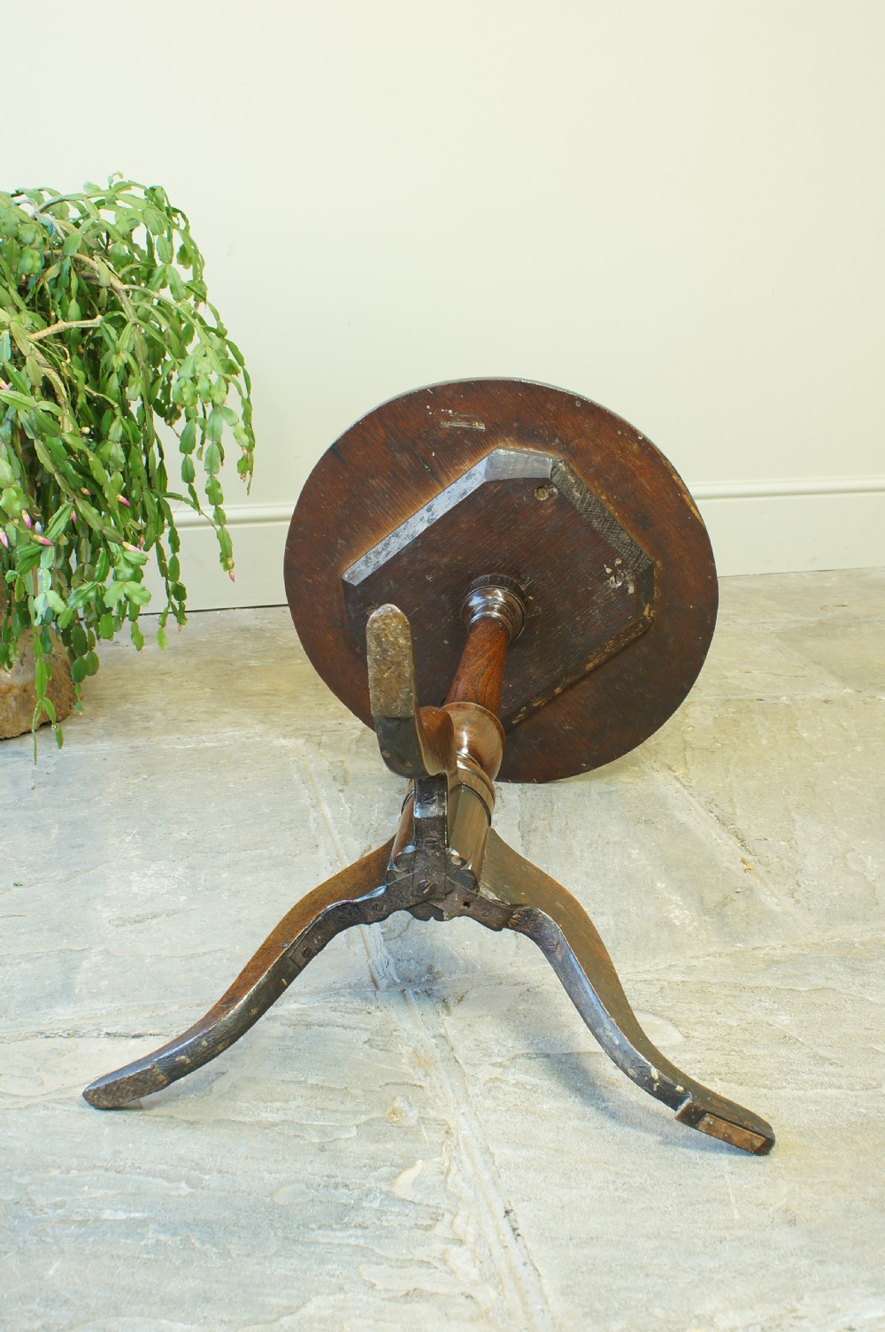 A small circular 18th-century oak tripod table with a turned central column and three curving legs, viewed from above against a neutral background. View III