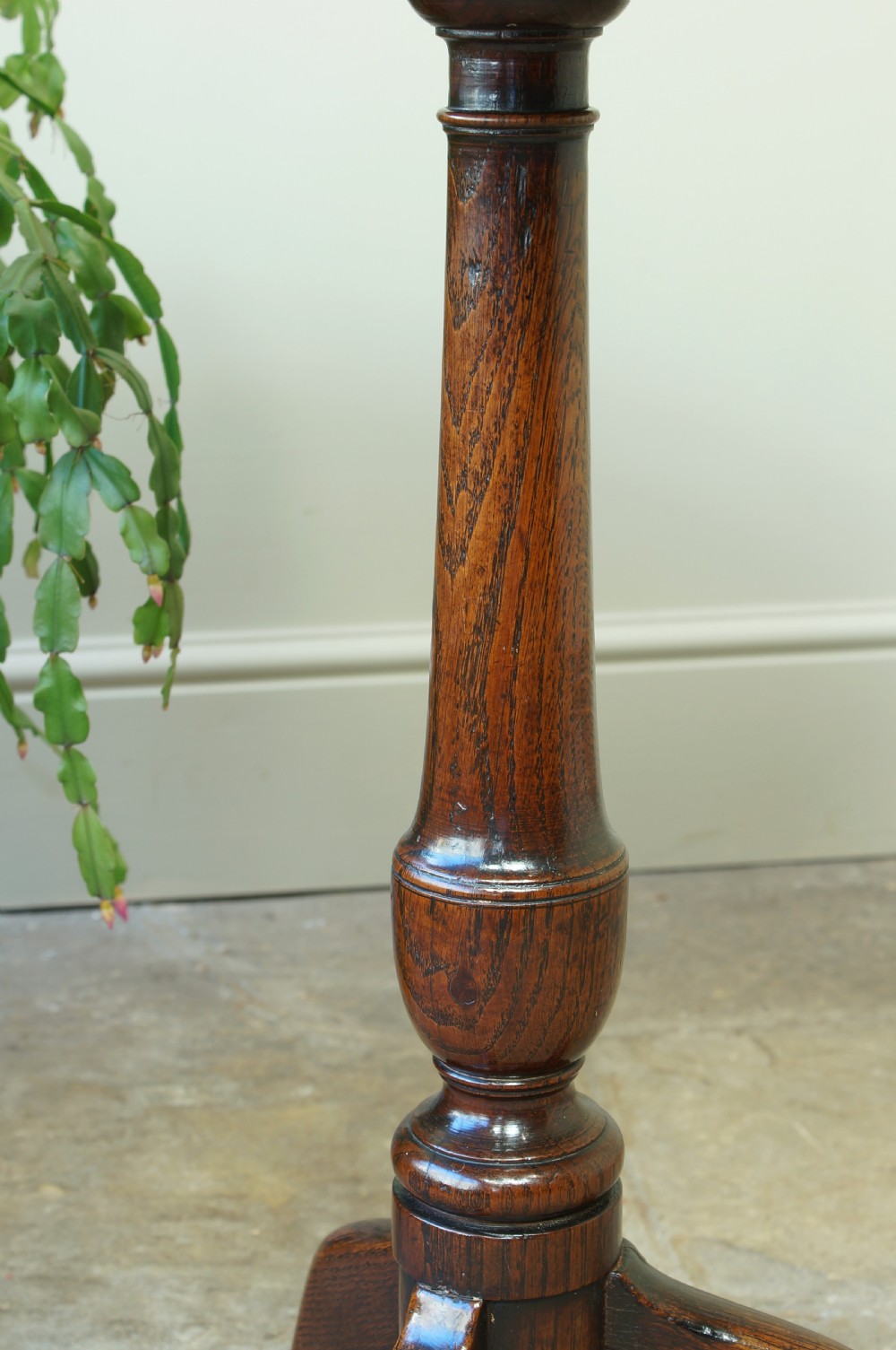 A small circular 18th-century oak tripod table with a turned central column and three curving legs, viewed from above against a neutral background. View V