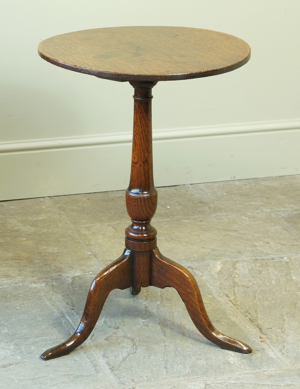 A small circular 18th-century oak tripod table with a turned central column and three curving legs, viewed from above against a neutral background. View VIII