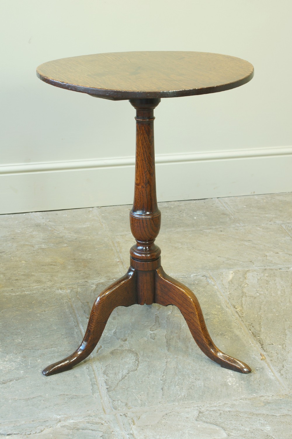 A small circular 18th-century oak tripod table with a turned central column and three curving legs, viewed from above against a neutral background. View IX