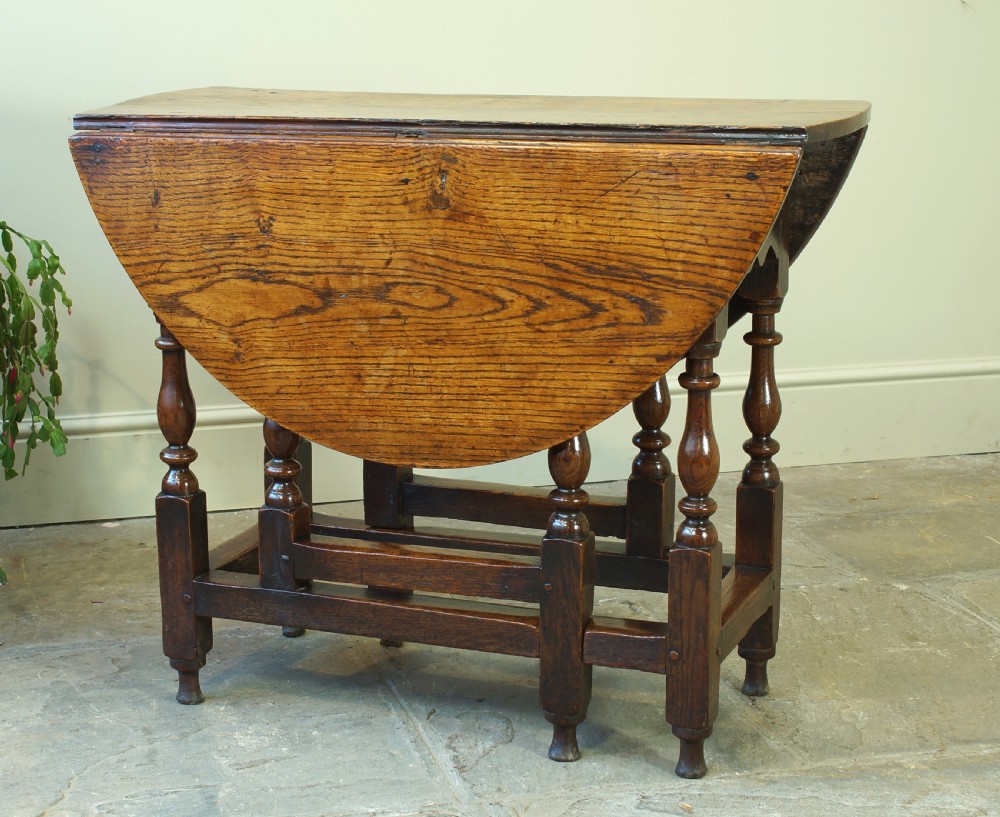 A small 17th-century oak gateleg table with two drop leaves, turned legs, and lower box stretchers.