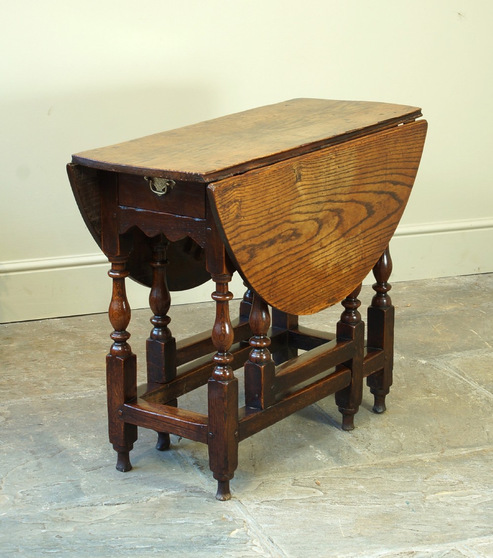A small 17th-century oak gateleg table with two drop leaves, turned legs, and lower box stretchers. View III