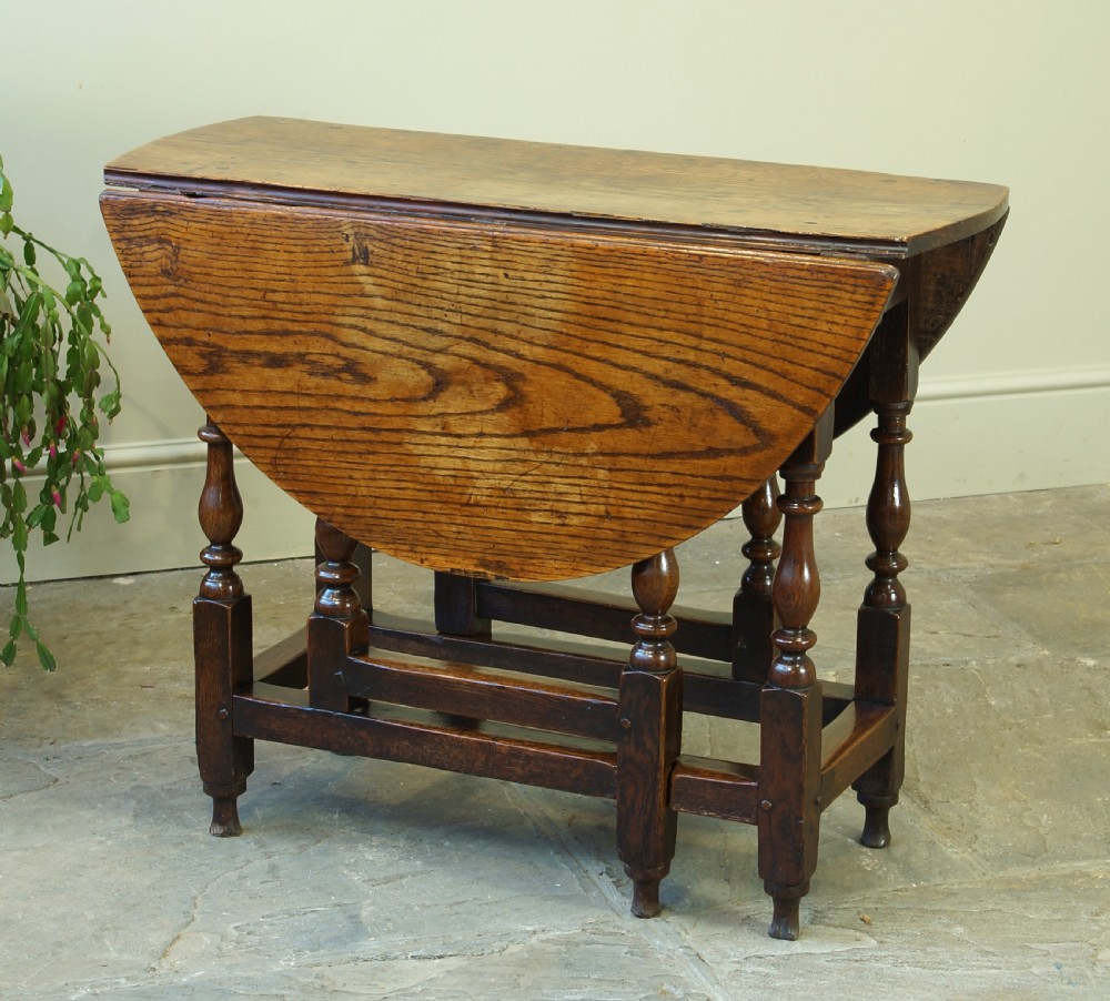 A small 17th-century oak gateleg table with two drop leaves, turned legs, and lower box stretchers. View V