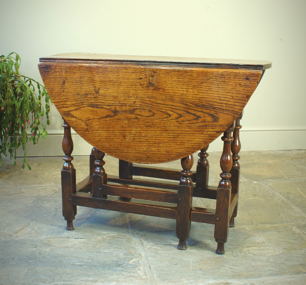 A small 17th-century oak gateleg table with two drop leaves, turned legs, and lower box stretchers. View IX