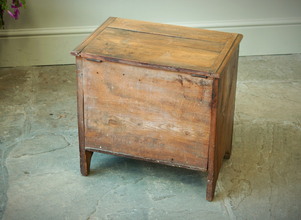 A Georgian plumwood close stool disguised as a small three-drawer chest with turned wooden knobs and bracket feet. View IV