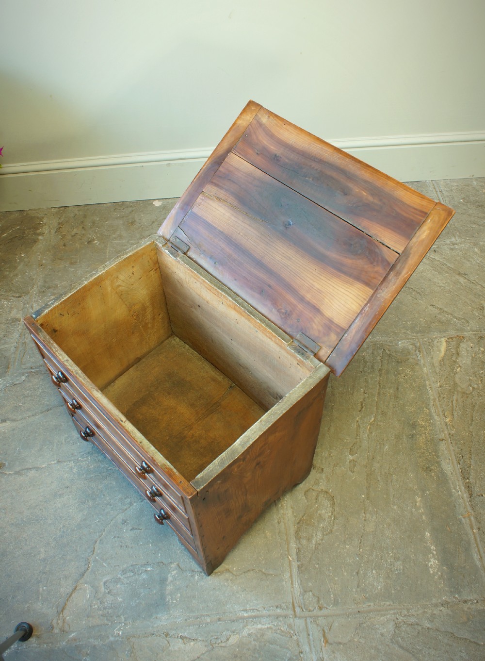 A Georgian plumwood close stool disguised as a small three-drawer chest with turned wooden knobs and bracket feet. View V