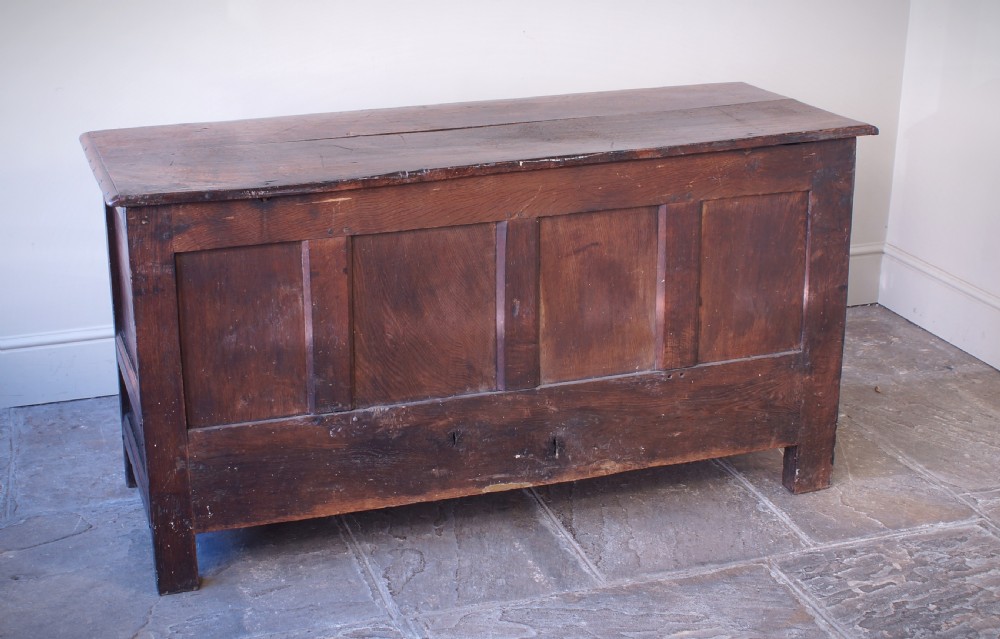 A 17th-century dark oak mule chest featuring carved friezes, three inlaid marquetry front panels with bird motifs, and two lower drawers with brass drop handles. View IX