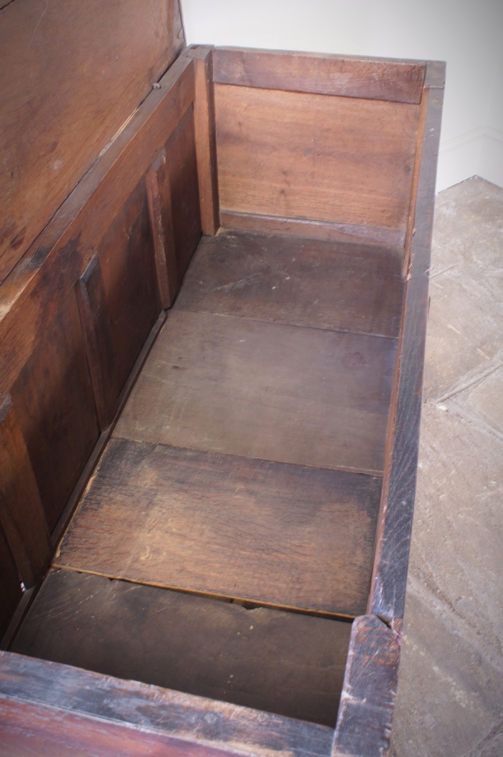 A 17th-century dark oak mule chest featuring carved friezes, three inlaid marquetry front panels with bird motifs, and two lower drawers with brass drop handles. View XI