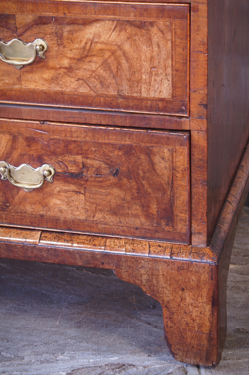 An 18th-century George II walnut bureau featuring a slant-front lid above four graduated drawers with brass handles, supported by bracket feet. View II