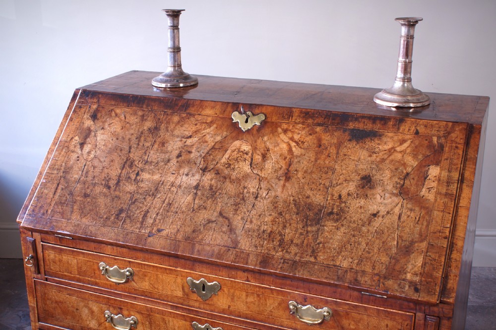 An 18th-century George II walnut bureau featuring a slant-front lid above four graduated drawers with brass handles, supported by bracket feet. View III