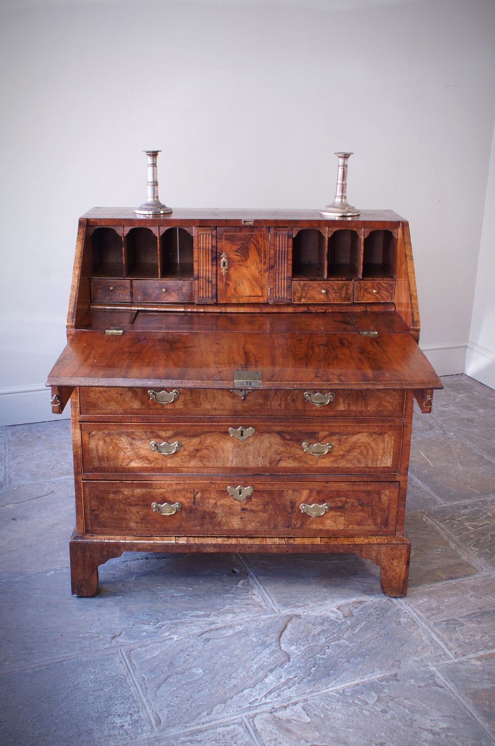 An 18th-century George II walnut bureau featuring a slant-front lid above four graduated drawers with brass handles, supported by bracket feet. View VII