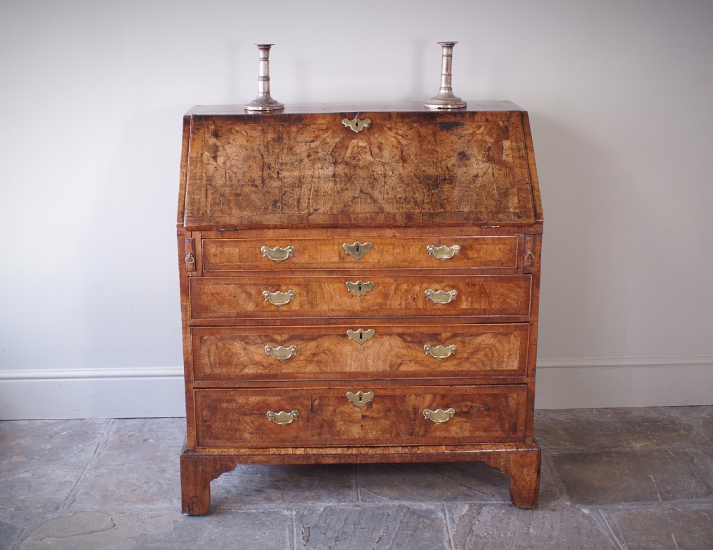 An 18th-century George II walnut bureau featuring a slant-front lid above four graduated drawers with brass handles, supported by bracket feet. View IX