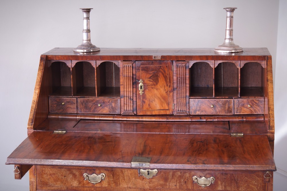An 18th-century George II walnut bureau featuring a slant-front lid above four graduated drawers with brass handles, supported by bracket feet. View XII