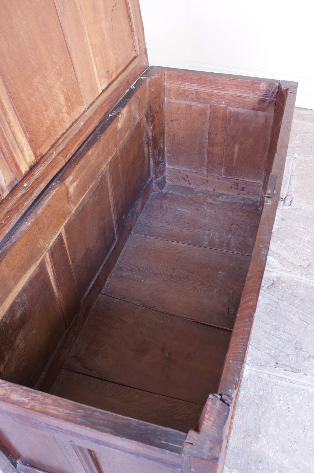 A 17th-century dark carved oak joined coffer featuring intricate carved panels and a carved date of 1670 across the top frieze. View VII