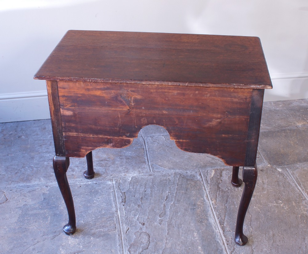 An 18th-century oak lowboy side table featuring cabriole legs, multiple drawers with brass swing handles, and an arched apron detail. View III