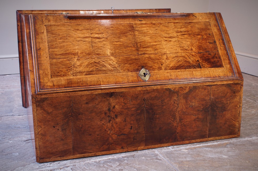 An early 18th-century walnut writing bureau featuring a sloping drop-front lid, brass drop handles, and turned bun feet. View XV