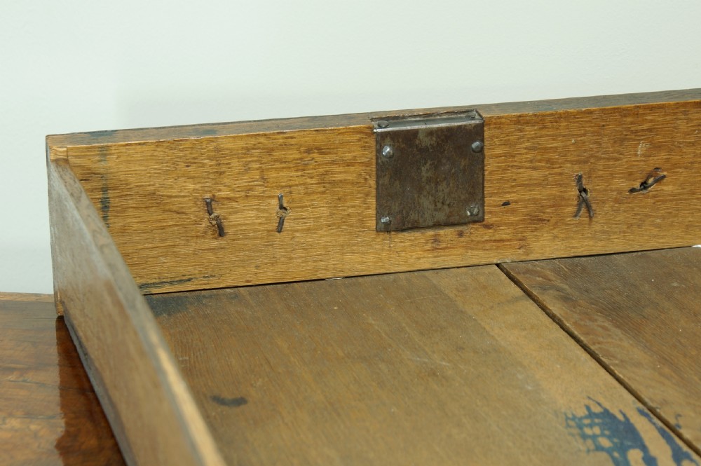 An early 18th-century walnut writing bureau featuring a sloping drop-front lid, brass drop handles, and turned bun feet. View XVIII