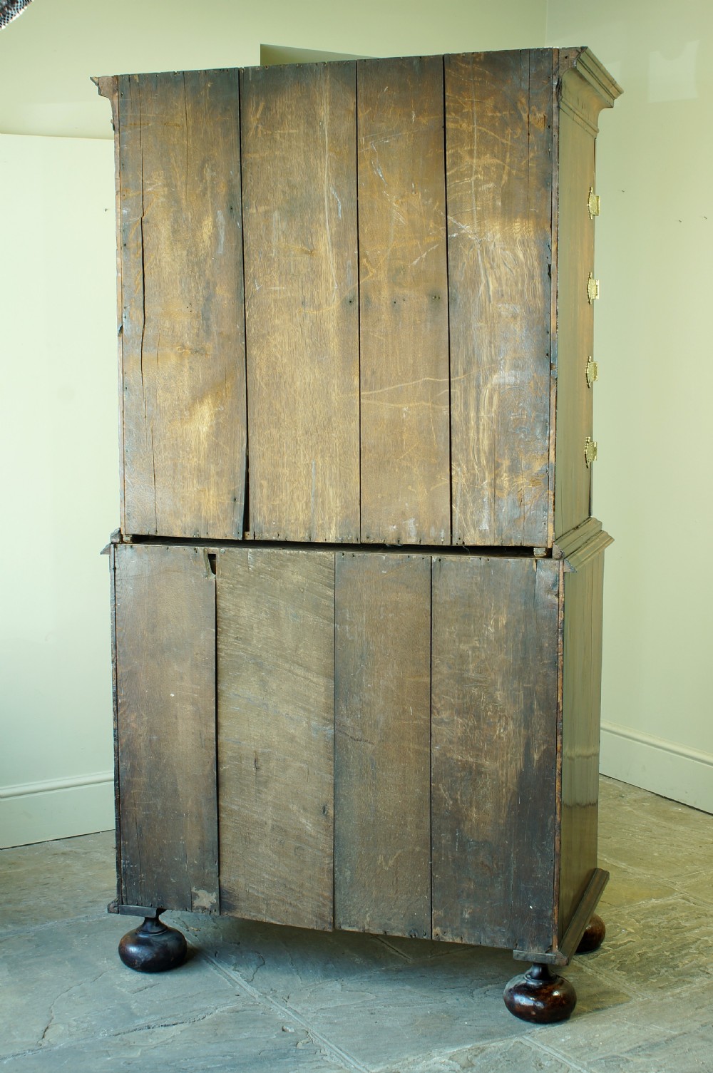 An early eighteenth-century burr walnut cabinet on chest featuring double upper doors with brass strap hinges above four graduated drawers, resting on turned bun feet. View XXVIII