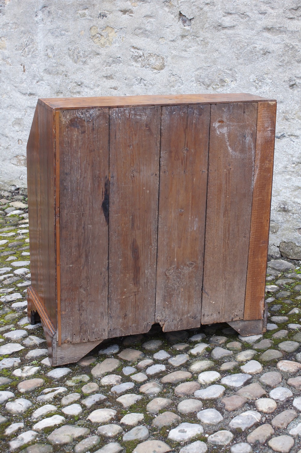 An early eighteenth-century elm slant-front bureau featuring four graduated drawers with brass drop handles and bracket feet. View VII