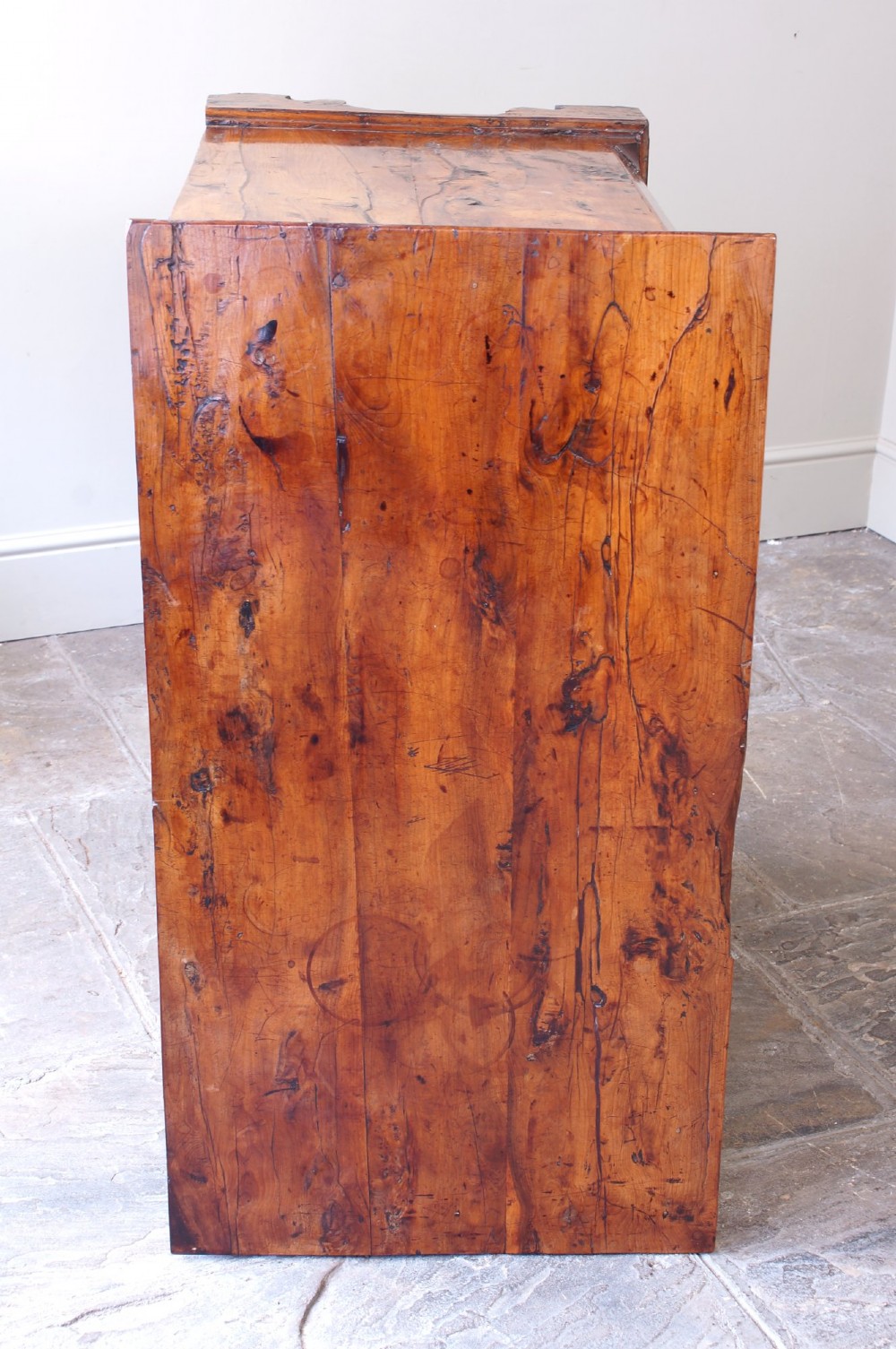 An 18th-century Georgian chest of drawers crafted from highly figured warm honey-toned yew wood with two short drawers over three long drawers and brass batwing handles. View VII