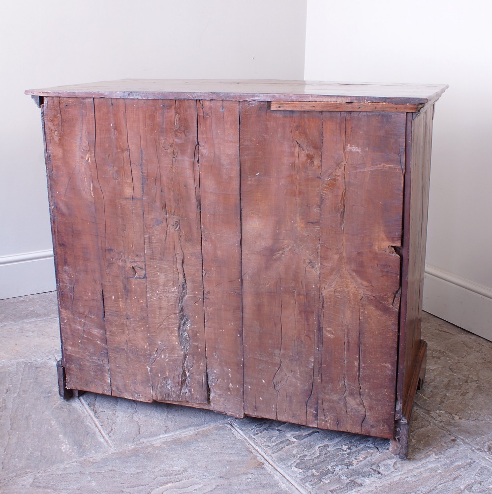 An 18th-century Georgian chest of drawers crafted from highly figured warm honey-toned yew wood with two short drawers over three long drawers and brass batwing handles. View IX