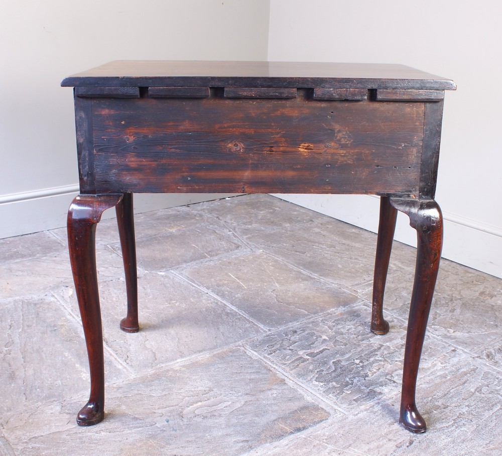 A mid-18th century George II mahogany lowboy featuring three drawers with brass handles, a shaped apron, and four cabriole legs ending in pad feet. View VI