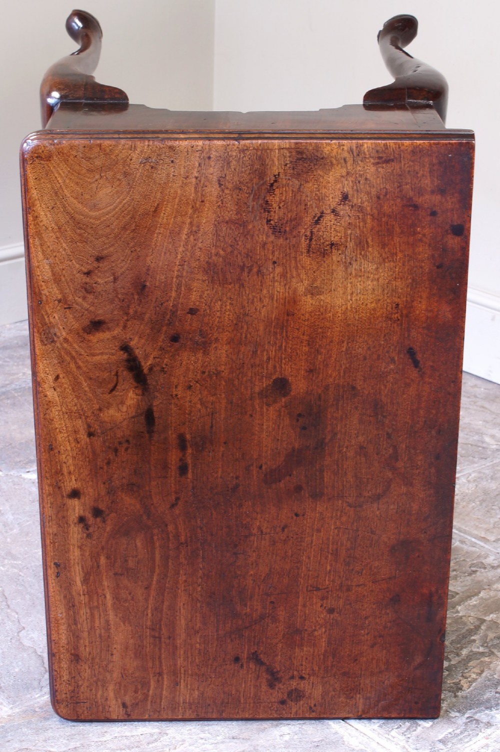 A mid-18th century George II mahogany lowboy featuring three drawers with brass handles, a shaped apron, and four cabriole legs ending in pad feet. View X