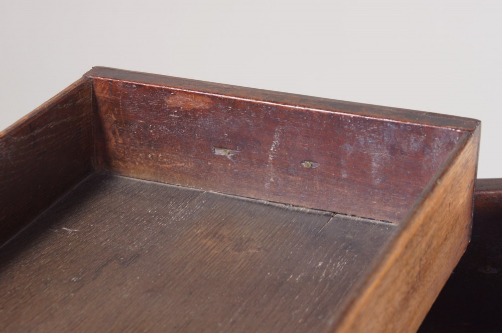 A mid-18th century George II mahogany lowboy featuring three drawers with brass handles, a shaped apron, and four cabriole legs ending in pad feet. View XIV