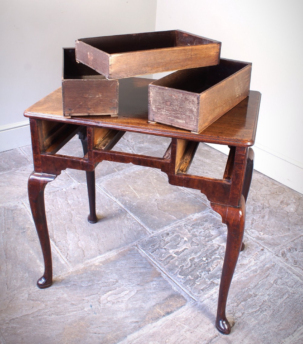 A mid-18th century George II mahogany lowboy featuring three drawers with brass handles, a shaped apron, and four cabriole legs ending in pad feet. View XV