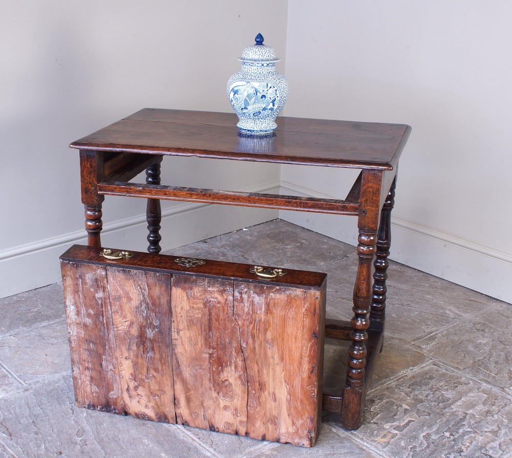 A late 17th-century dark oak side table featuring a single drawer with brass handles, turned legs, and a rectangular stretcher base. View VII