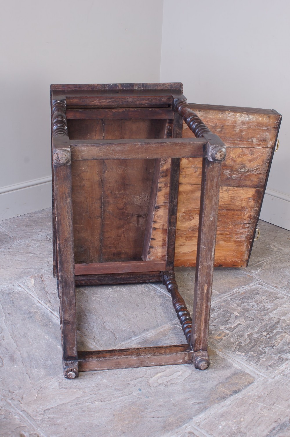 A late 17th-century dark oak side table featuring a single drawer with brass handles, turned legs, and a rectangular stretcher base. View VIII