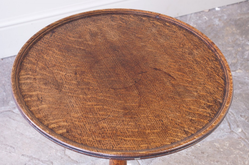 An 18th-century dark oak tripod table featuring a circular top, turned central baluster stem, and three splayed legs. View II