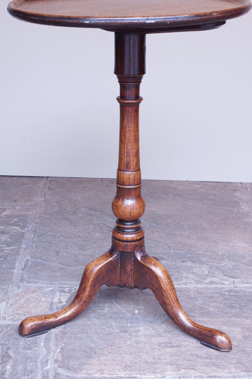 An 18th-century dark oak tripod table featuring a circular top, turned central baluster stem, and three splayed legs. View III