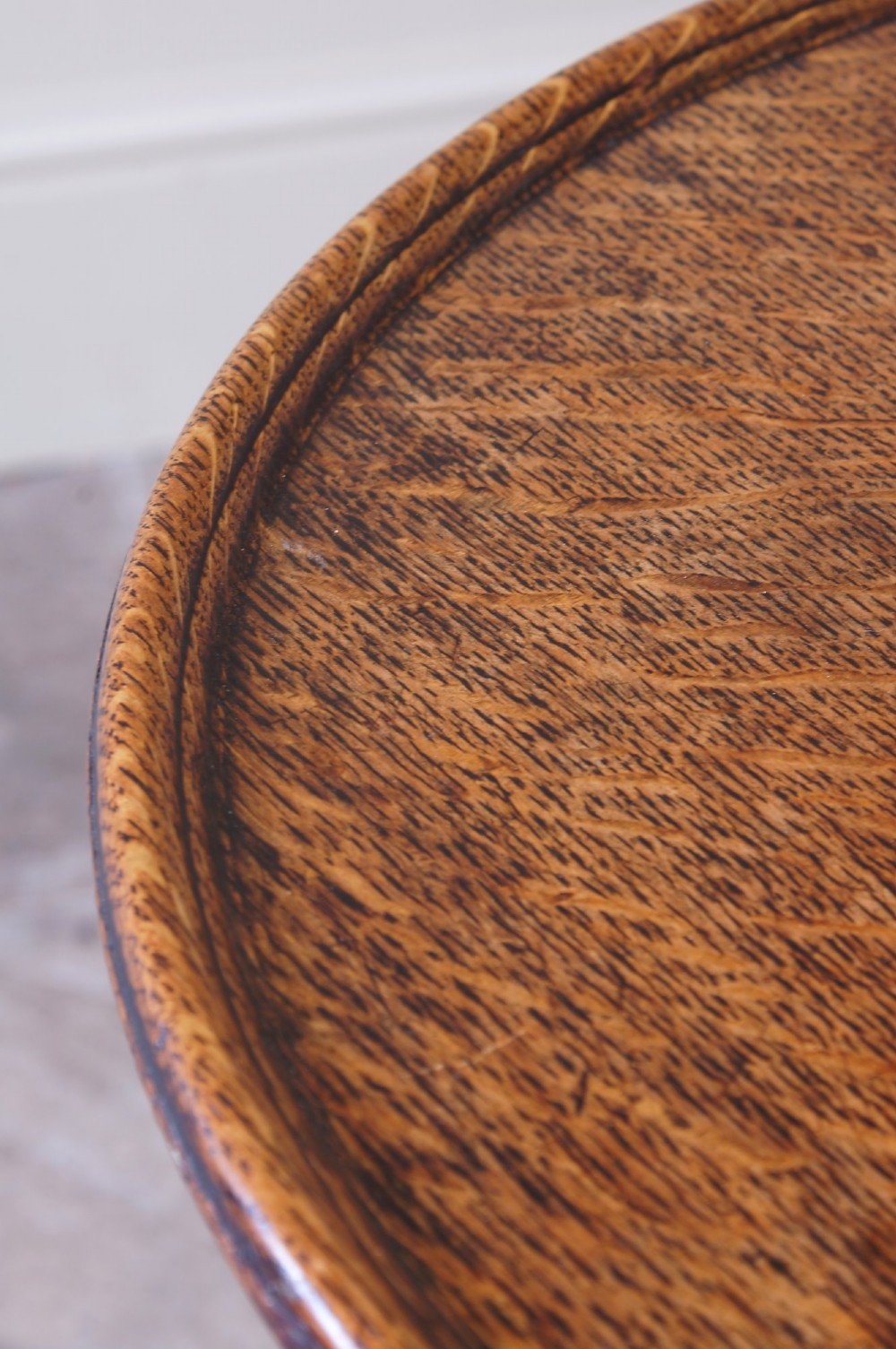 An 18th-century dark oak tripod table featuring a circular top, turned central baluster stem, and three splayed legs. View V
