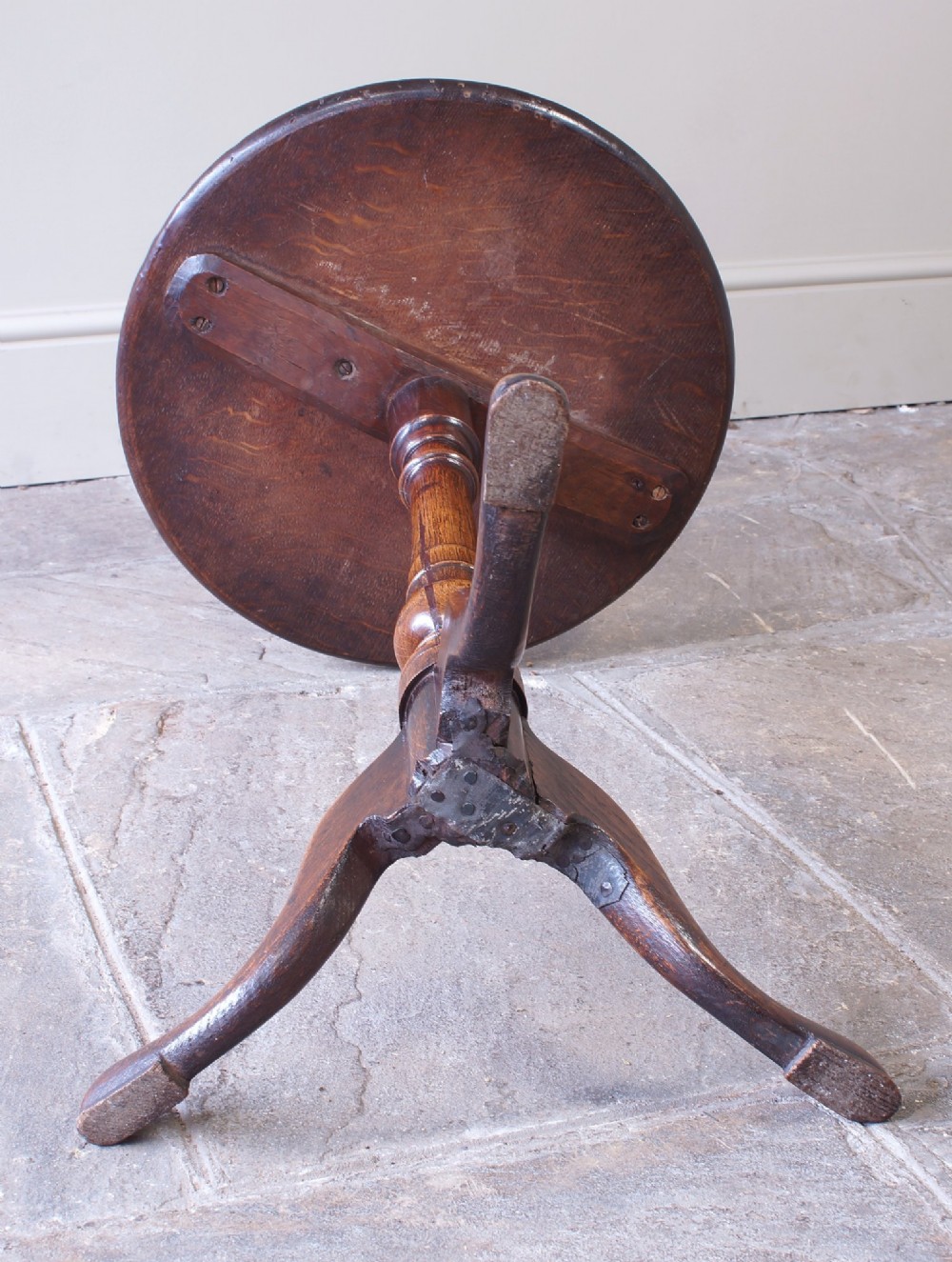An 18th-century dark oak tripod table featuring a circular top, turned central baluster stem, and three splayed legs. View VI