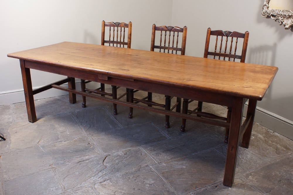 A rectangular 19th-century French cherry wood dining table featuring a plank top, straight legs, and lower H-stretchers. View II