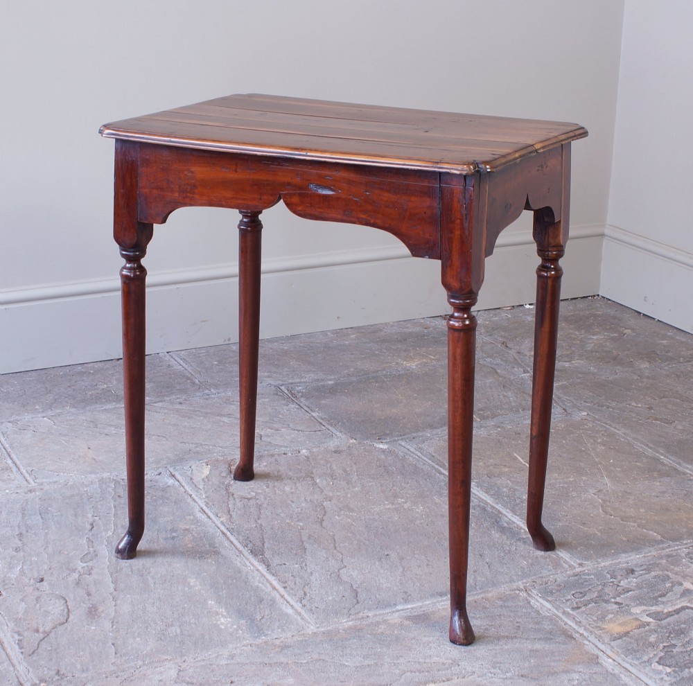 An early 18th-century fruitwood centre table featuring a rectangular plank top, a scalloped apron, and slender turned legs ending in pad feet. View II