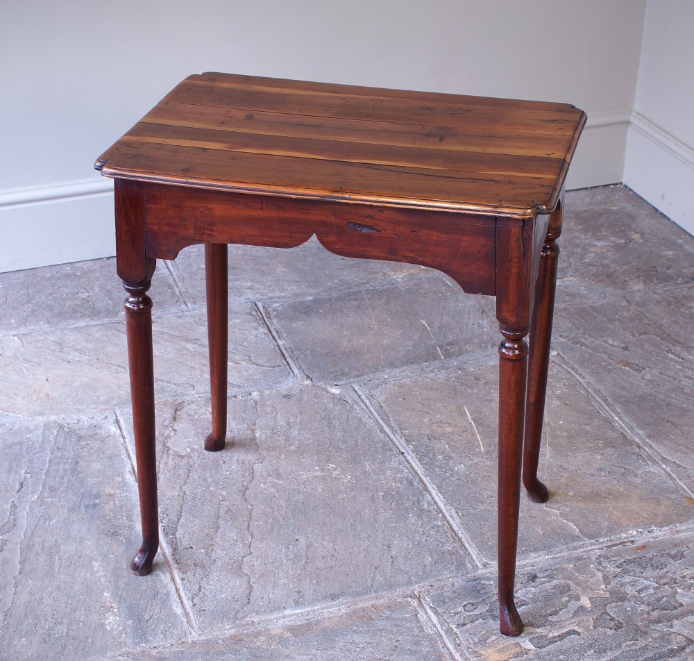 An early 18th-century fruitwood centre table featuring a rectangular plank top, a scalloped apron, and slender turned legs ending in pad feet. View III