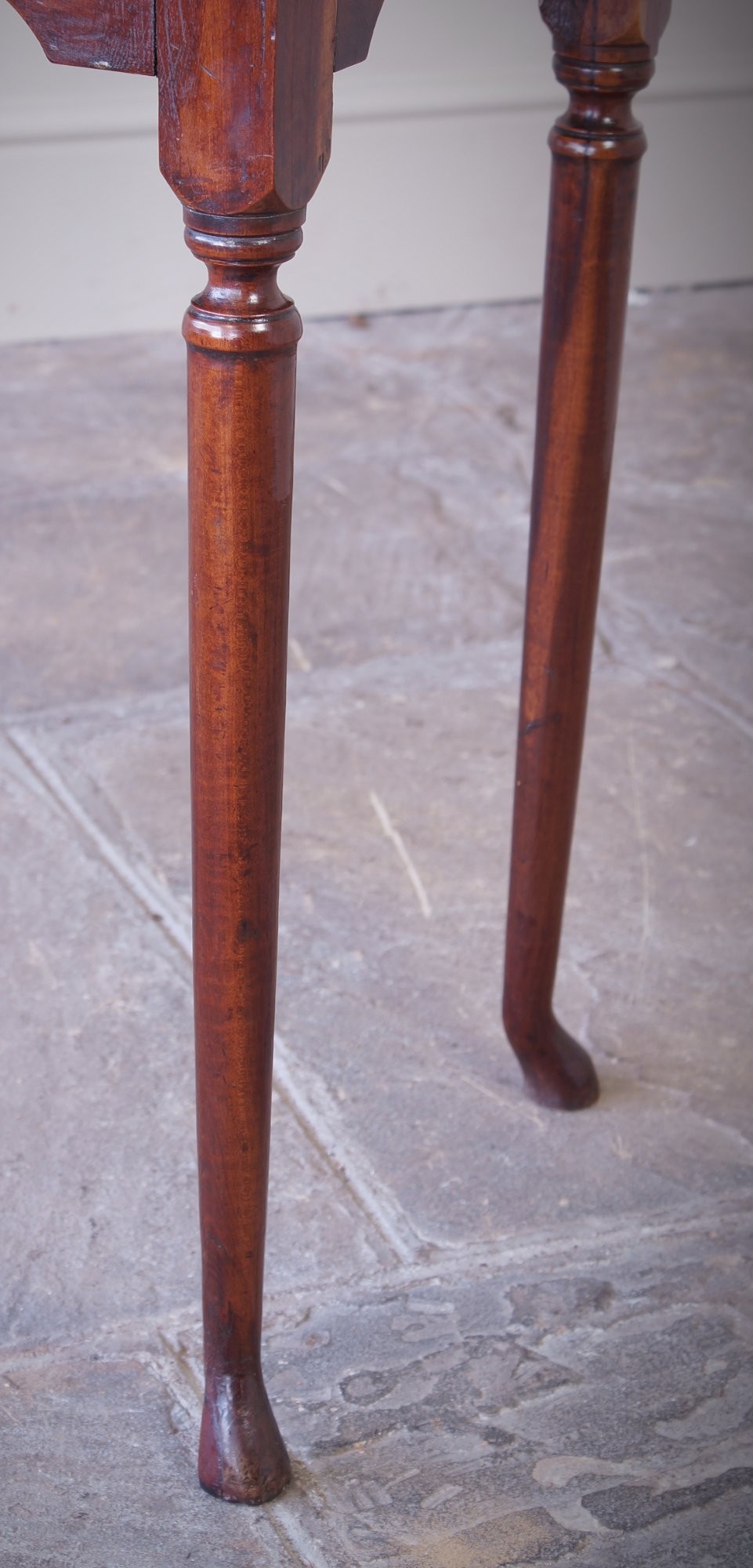 An early 18th-century fruitwood centre table featuring a rectangular plank top, a scalloped apron, and slender turned legs ending in pad feet. View VI