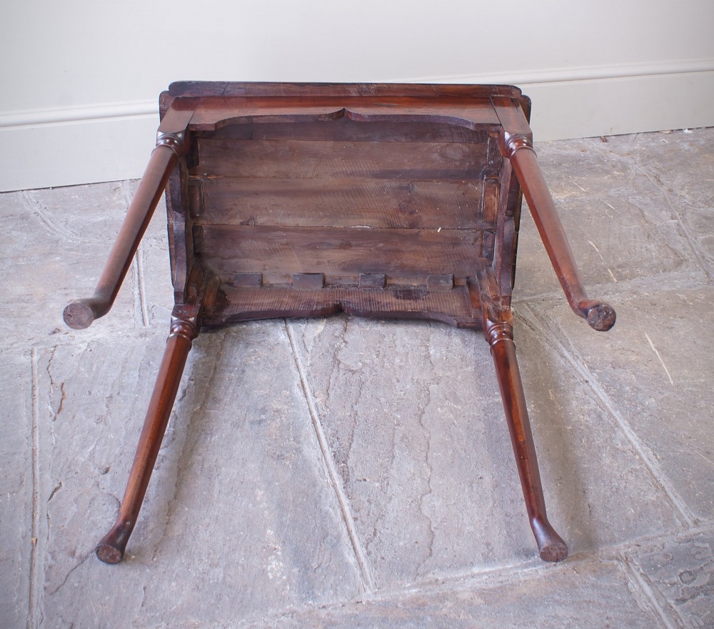 An early 18th-century fruitwood centre table featuring a rectangular plank top, a scalloped apron, and slender turned legs ending in pad feet. View XI