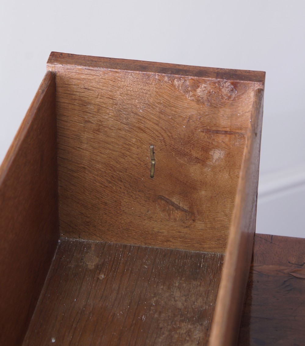 An early 18th-century walnut lowboy table with three drawers, brass ring pull handles, a scalloped apron, and cabriole legs ending in pad feet. View VI