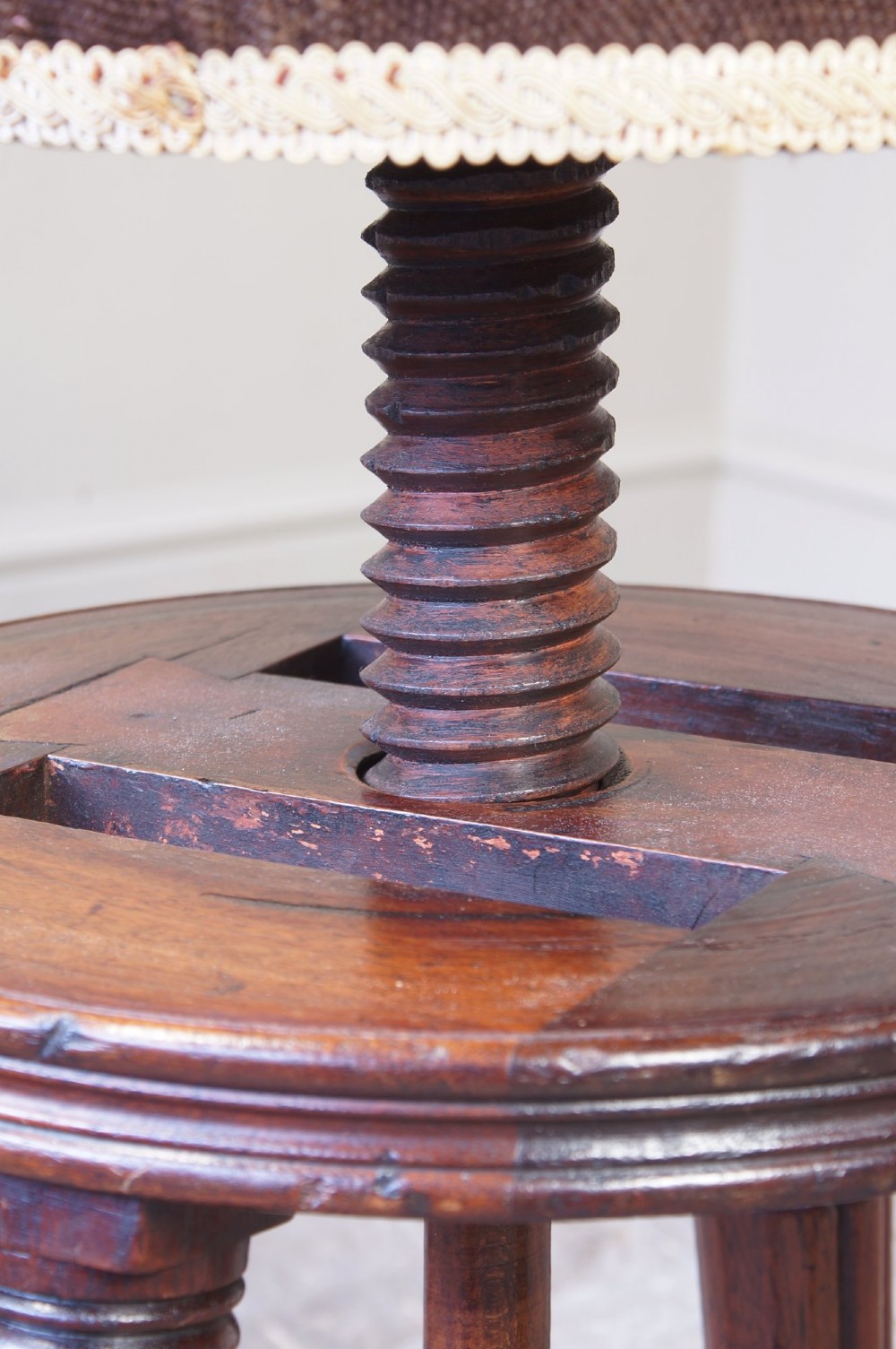 A Regency mahogany revolving piano stool featuring a circular floral needlepoint cushion, central wooden screw mechanism, and fluted turned legs. View IV