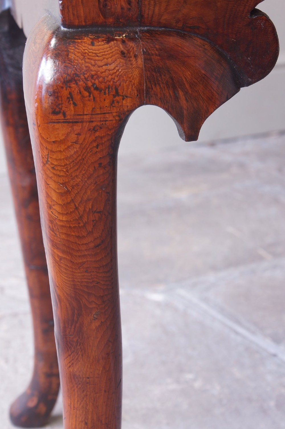 An 18th-century yew wood lowboy table featuring three drawers, a shaped scalloped apron, metal knob handles, and cabriole legs. View VIII