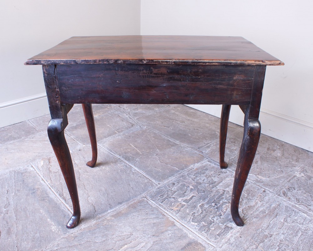 An 18th-century yew wood lowboy table featuring three drawers, a shaped scalloped apron, metal knob handles, and cabriole legs. View XII