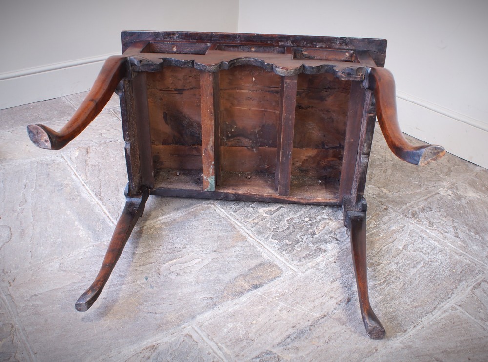 An 18th-century yew wood lowboy table featuring three drawers, a shaped scalloped apron, metal knob handles, and cabriole legs. View XIV
