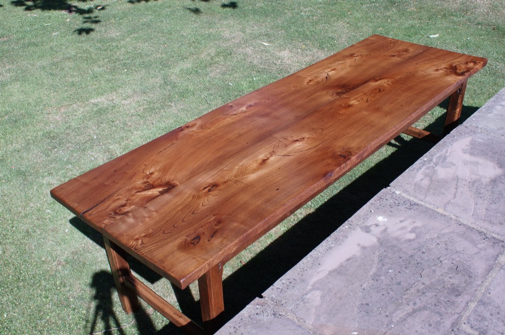 A long nineteenth-century elm farmhouse dining table with a thick plank top, straight legs, and side stretchers. View V